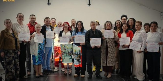 Grupo de personas con su diploma acomapañados de funcionaros de la alcaldía