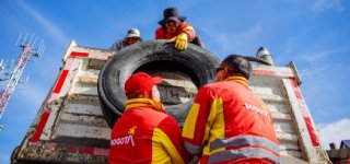 Funcionarios recogiendo llantas en la localidad con una volqueta
